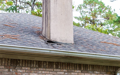 damaged roof with chimney showing signs of wear and tear indicating need for repair maintenance and inspection