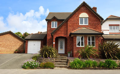 brick house with driveway surrounded by green plants and flowers in a suburban neighborhood showcasing eight stylish features